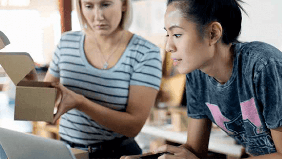 Two women working together on a laptop