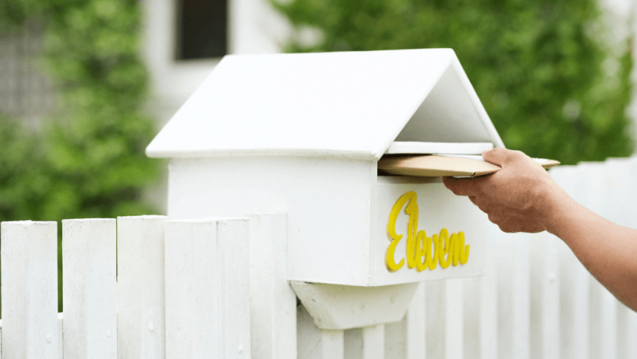 Hand inserting large envelope into mailbox